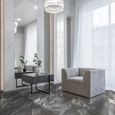 Sala luminosa con ventanas grandes y cortinas blancas, sofá gris y un piso de cerámica mármol Nobile
