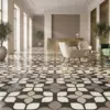 Sala de espera amplia y luminosa con ventanales grandes, sofás beige y un piso de cerámica rústica Tesela