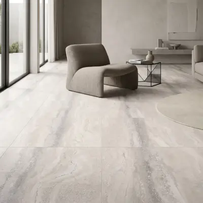 Sala luminosa con ventanas grandes, sofá color gris oscuro y un piso de cerámica mármol Vittoria