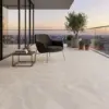 Terrzaza con vista a la ciudad adornada con una planta de exterior y piso Cerámica Piedra Aureon con efecto arena